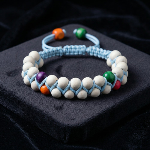 «دستبند ماکرامه آبی با مهرههای چوبی روشن و رنگی، قابل تنظیم با دو مهره انتهایی»